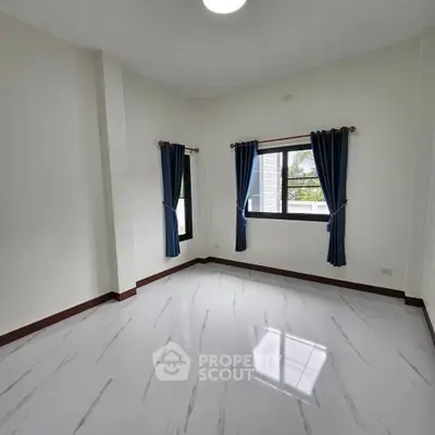 Spacious empty room with large windows and elegant curtains, perfect for customization.