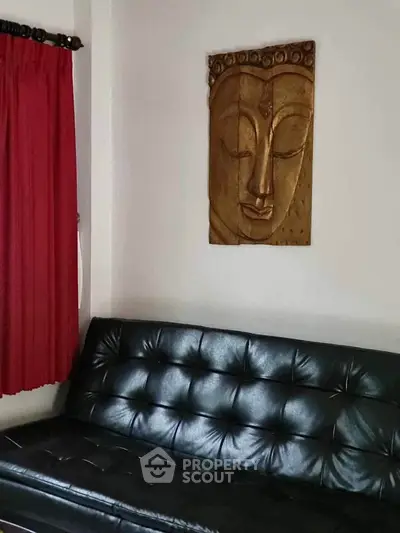 Stylish living room with black leather sofa and elegant wall art