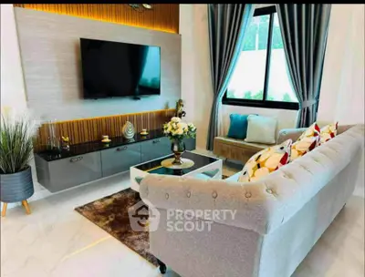 Luxurious living room with elegant sofa, modern TV setup, and stylish decor.