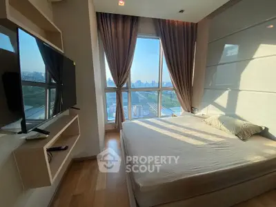 Modern bedroom with large window offering stunning city view, featuring sleek design and natural light.