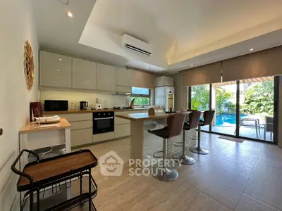 Modern kitchen with island, open layout, and pool view, perfect for entertaining and family gatherings.
