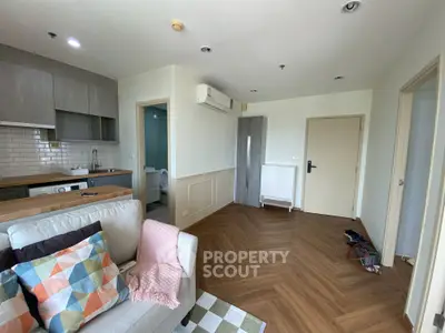 Cozy living room with open kitchen and modern decor in a stylish apartment.