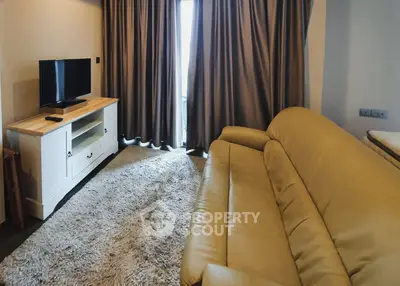 Cozy living room with plush sofa and TV stand, perfect for relaxation.