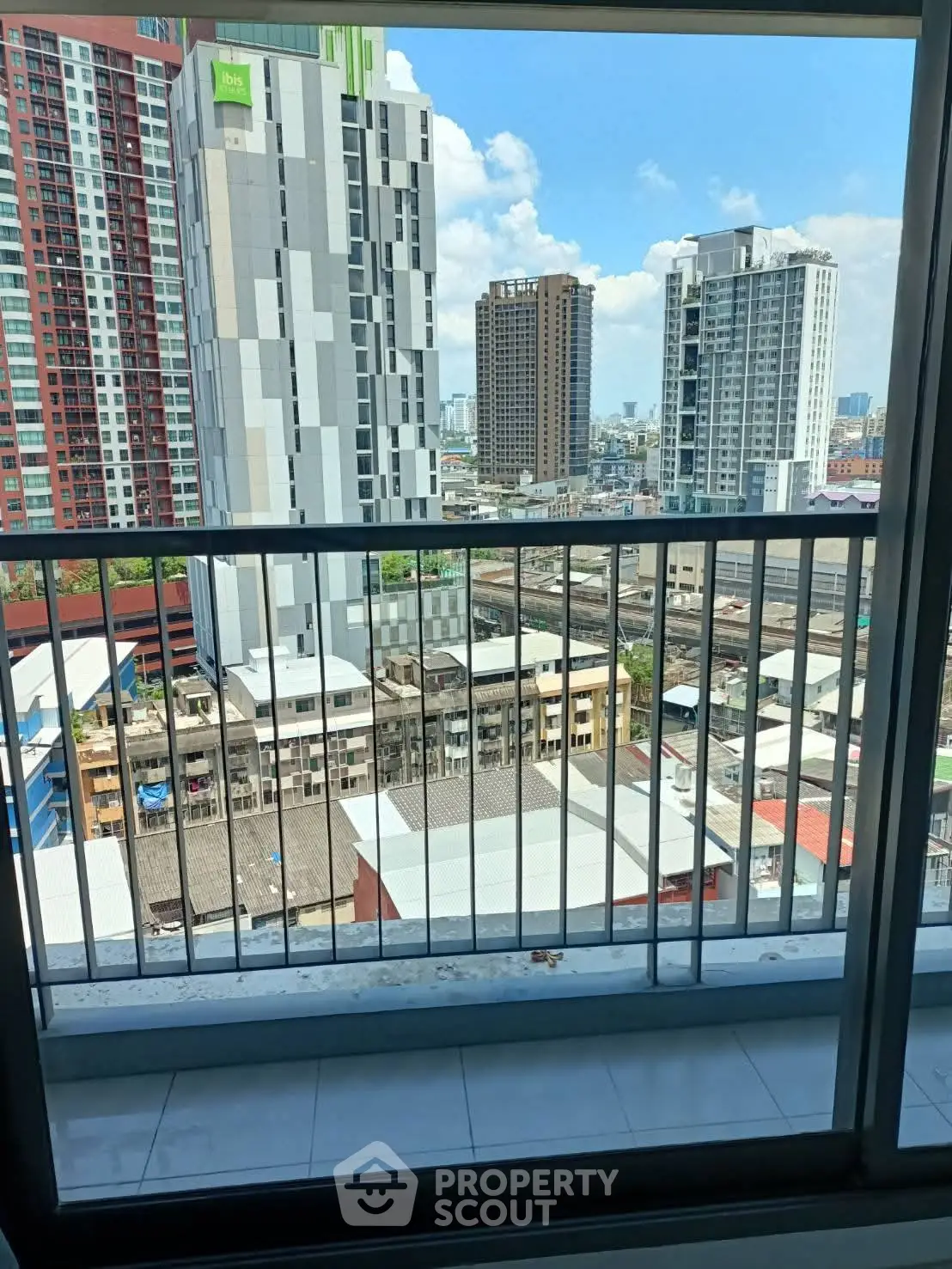 Stunning urban view from a high-rise balcony overlooking cityscape and modern buildings.