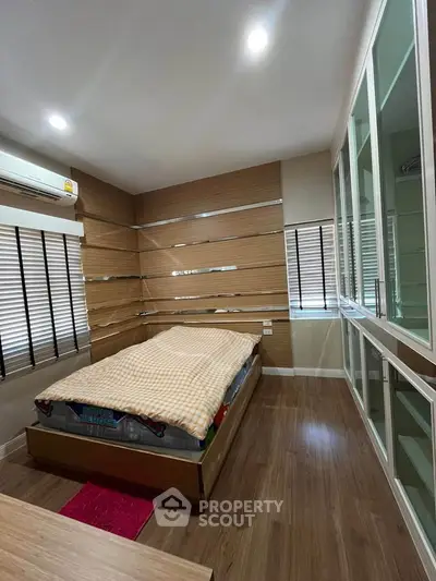 Modern bedroom with wooden flooring and built-in wardrobe