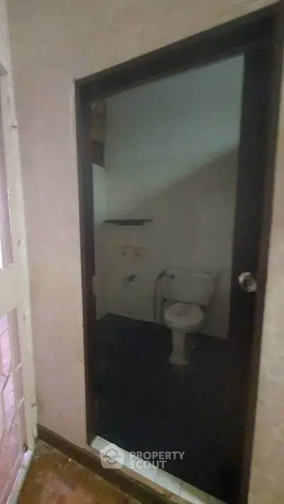 Compact bathroom with basic fixtures and dark flooring, ideal for small spaces.