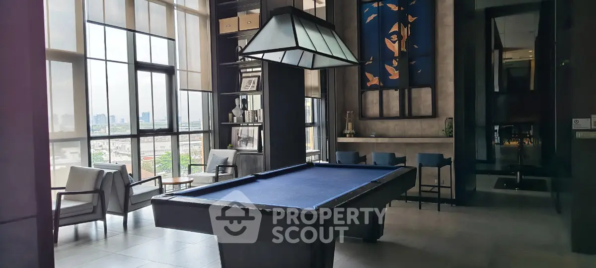 Luxurious high-rise lounge with pool table and city view, perfect for relaxation and entertainment.