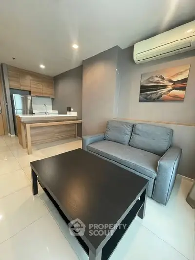 Modern open-layout kitchen and living room with sleek furniture and air conditioning.