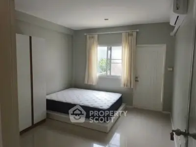 Spacious bedroom with natural light, featuring a comfortable bed and modern wardrobe.