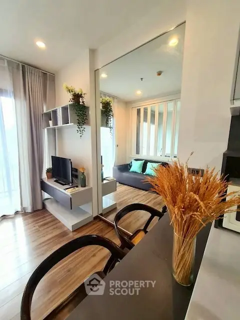 Modern living room with stylish decor and natural light, featuring a cozy seating area and sleek furniture.