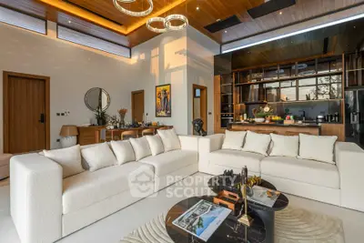 Luxurious modern living room with open kitchen, elegant decor, and natural light.