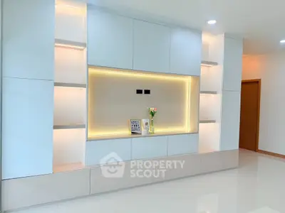 Modern minimalist living room with built-in shelving and ambient lighting