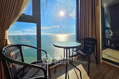 Stunning ocean view from a cozy balcony with seating area, perfect for relaxation and enjoying sunsets.