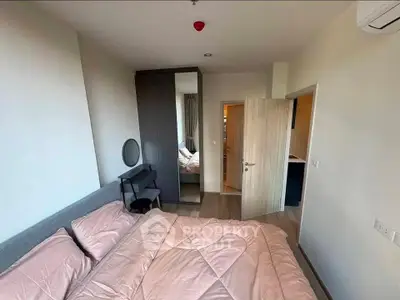 Cozy bedroom with modern decor and ample natural light, featuring a stylish wardrobe and comfortable bedding.