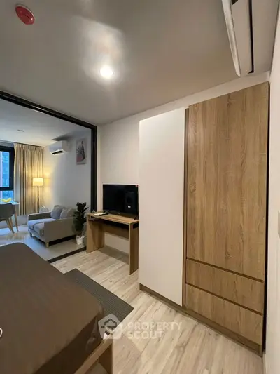 Modern studio apartment with cozy living area and stylish wooden furniture.