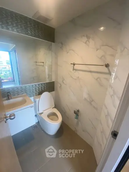 Modern bathroom with marble walls and sleek fixtures in a contemporary apartment.