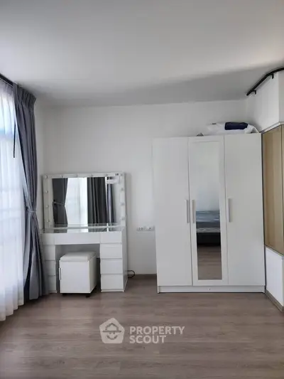 Spacious bedroom with modern wardrobe and vanity set, perfect for stylish living.