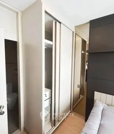 Modern bedroom with sleek built-in wardrobe and cozy bed setup.