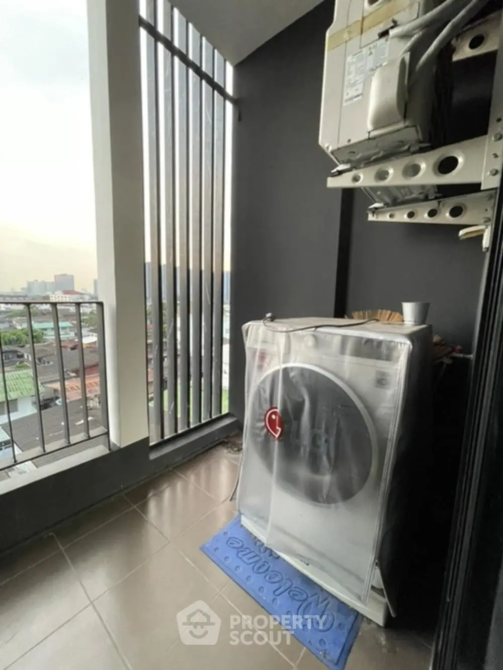 Compact balcony with city view and washing machine setup