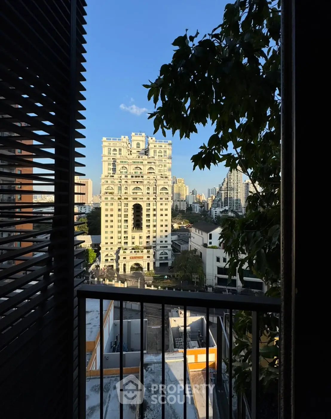 Stunning cityscape view from a modern balcony with lush greenery and iconic architecture.