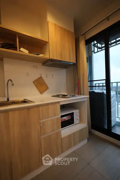 Modern kitchen with wooden cabinets and balcony view in stylish apartment