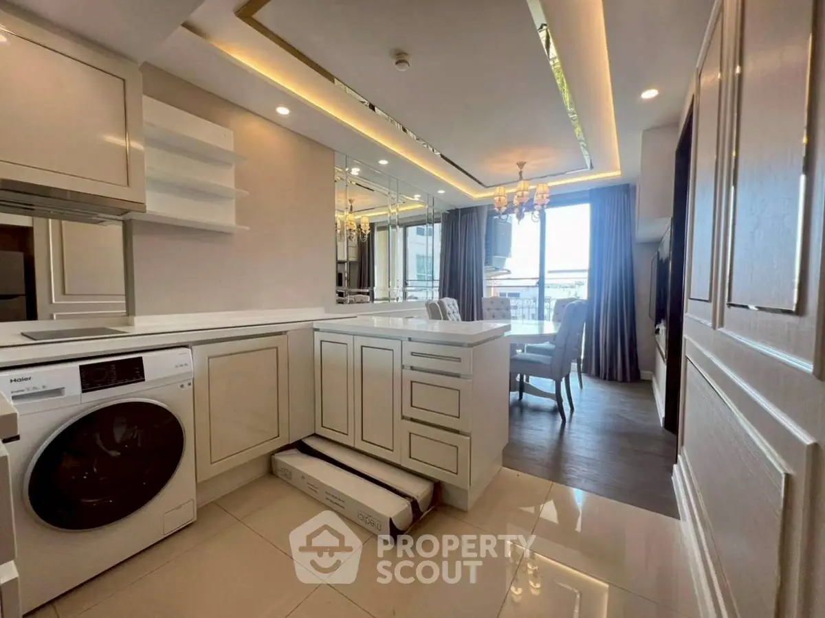 Luxurious modern kitchen with washing machine and elegant dining area, featuring chic lighting and stylish decor.