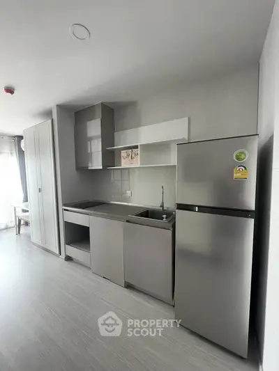 Modern kitchen with sleek stainless steel appliances and minimalist design in a bright apartment.