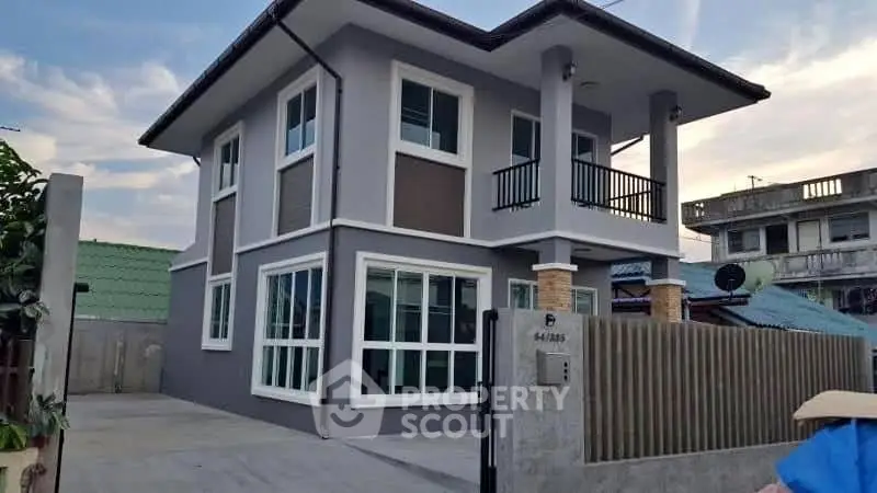 Modern two-story house with sleek design and spacious driveway in a suburban neighborhood.