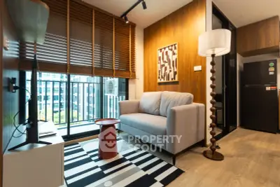 Modern living room with stylish decor, cozy sofa, and large window offering city views in a contemporary apartment.