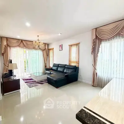 Spacious living room with elegant curtains and modern black leather sofa