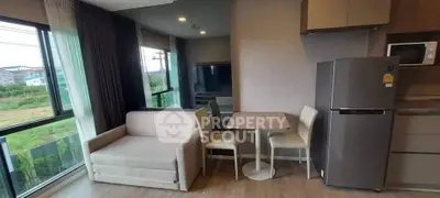 Modern living area with sofa, dining table, and kitchen appliances in a cozy apartment.