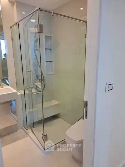 Modern bathroom with glass shower enclosure and sleek fixtures