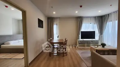 Spacious open-plan living room with dining area and large windows for natural light.