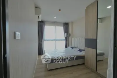 Modern bedroom with large window and stylish decor in a contemporary apartment.