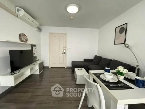 Modern living room with sleek furniture and dining area, featuring a cozy sofa and stylish decor.