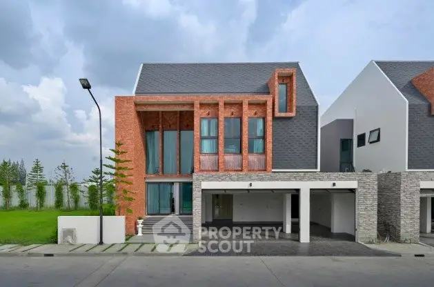 Modern two-story house with brick and stone facade, large windows, and spacious garage.