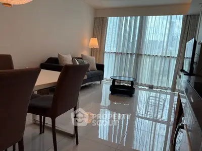 Modern living room with sleek furniture and large windows offering natural light.