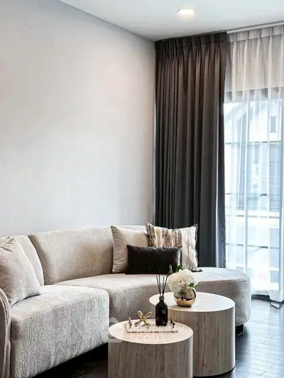 Elegant living room with modern beige sofa and stylish coffee tables.