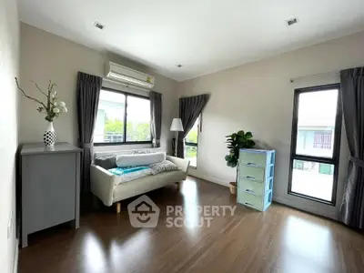 Spacious living room with modern decor and large windows offering natural light.