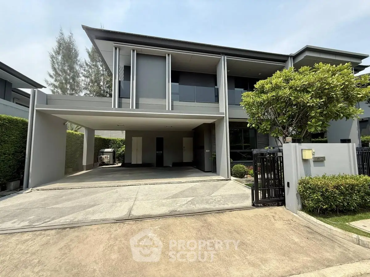 Modern two-story house with spacious driveway and lush greenery
