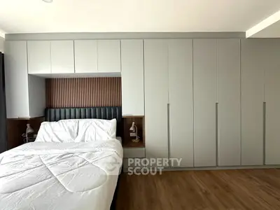 Modern bedroom with sleek built-in wardrobes and cozy bed setup