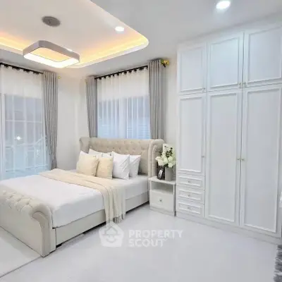 Luxurious bedroom with elegant decor and ample natural light, featuring a plush bed and spacious wardrobe.