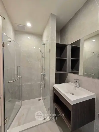 Modern bathroom with glass shower and sleek vanity in luxury apartment