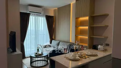 Modern living room with elegant decor and open kitchen layout, featuring stylish furniture and ambient lighting.