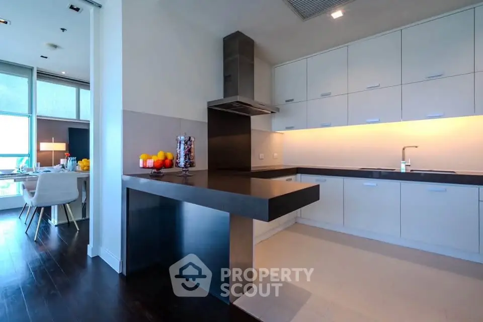 Modern kitchen with sleek cabinetry and open layout, adjacent to a stylish dining area with natural light.