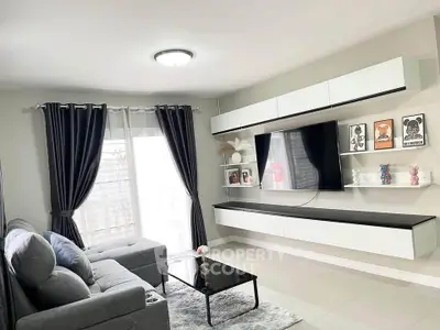 Modern living room with sleek furniture and wall-mounted TV, featuring elegant decor and natural light.