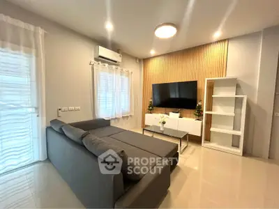 Modern living room with sleek gray sofa and wall-mounted TV