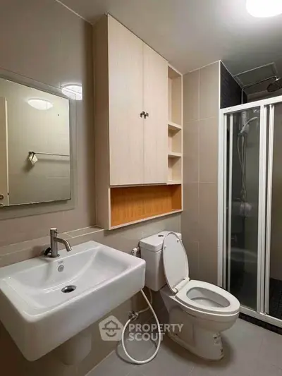 Modern bathroom with shower and sleek cabinetry in contemporary apartment.