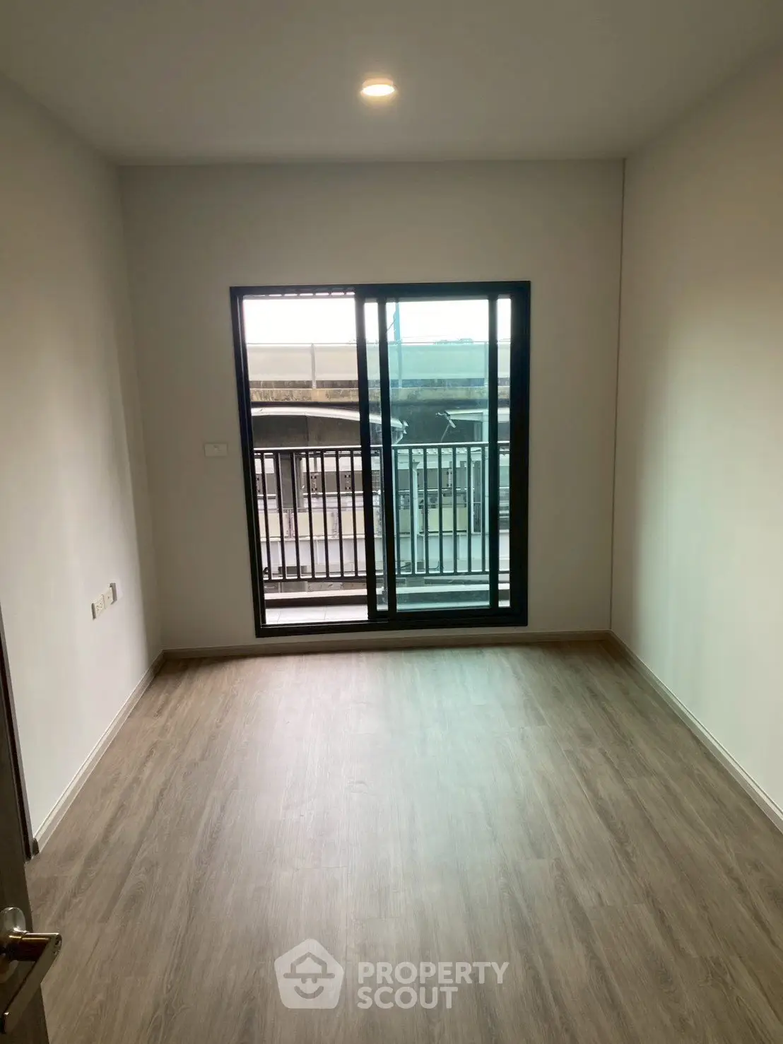 Spacious empty room with large window and balcony access, perfect for customization.