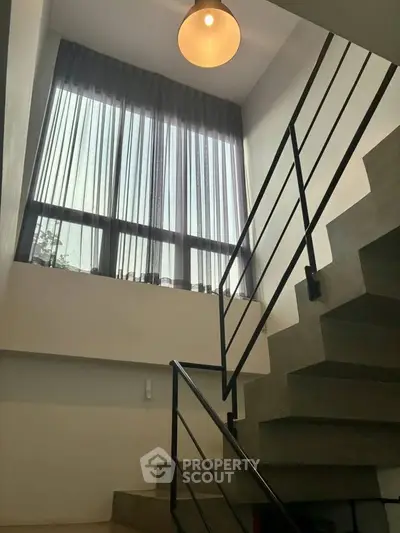 Modern staircase with large window and sleek railing in contemporary home
